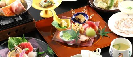Une variété de plats sont disposés sur la table, notamment des sushis, des sashimis et d’autres spécialités de la cuisine asiatique.