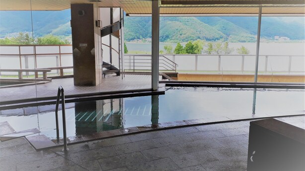 An indoor swimming pool with a view of a mountainous landscape. - Lakeland Hotel Mizunosato (Fujikawaguchiko)