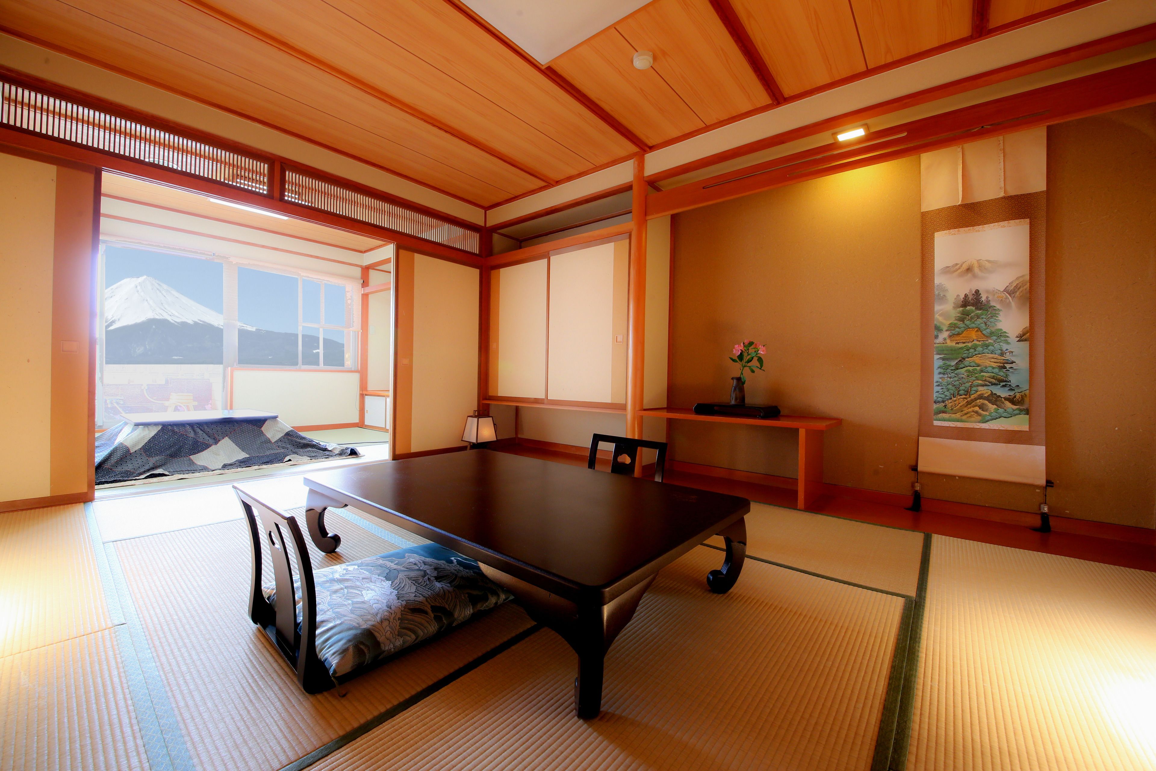 A traditional Japanese room with tatami flooring, a low table, and sliding doors.