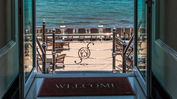 A view from inside a building to a beach with a 'WELCOME' mat at the entrance. - Suntosa Resort (Koh Lan)