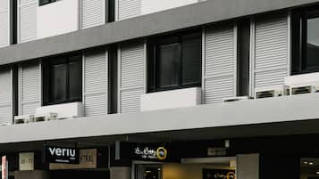 A modern building with multiple floors, featuring a ground-level restaurant named 'Le Resto'.