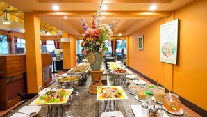 Montaje de bufé con diversas estaciones de comida y una decoración floral central.