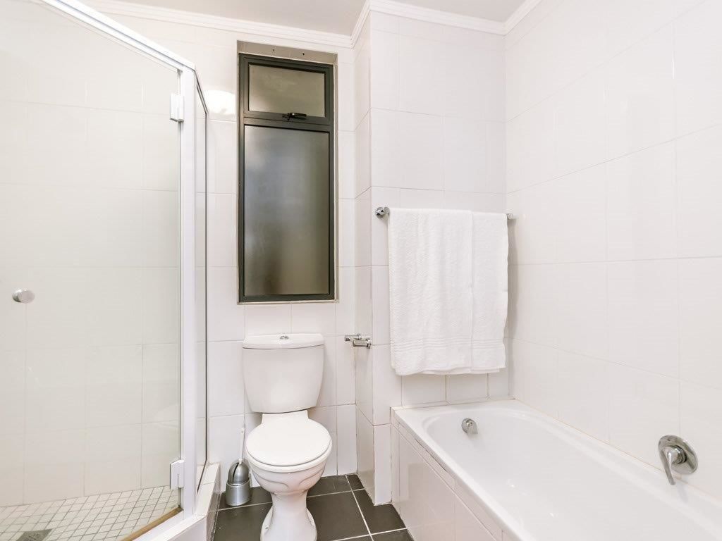 A bathroom with a toilet, a bathtub, and a shower.