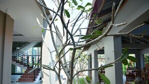 Un interior moderno con una escalera, una zona de comedor y un árbol.