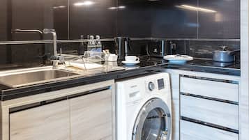 A modern kitchen with a stainless steel sink, dishwasher, and a built-in oven.