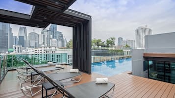 Una piscina al aire libre, sombrillas, tumbonas