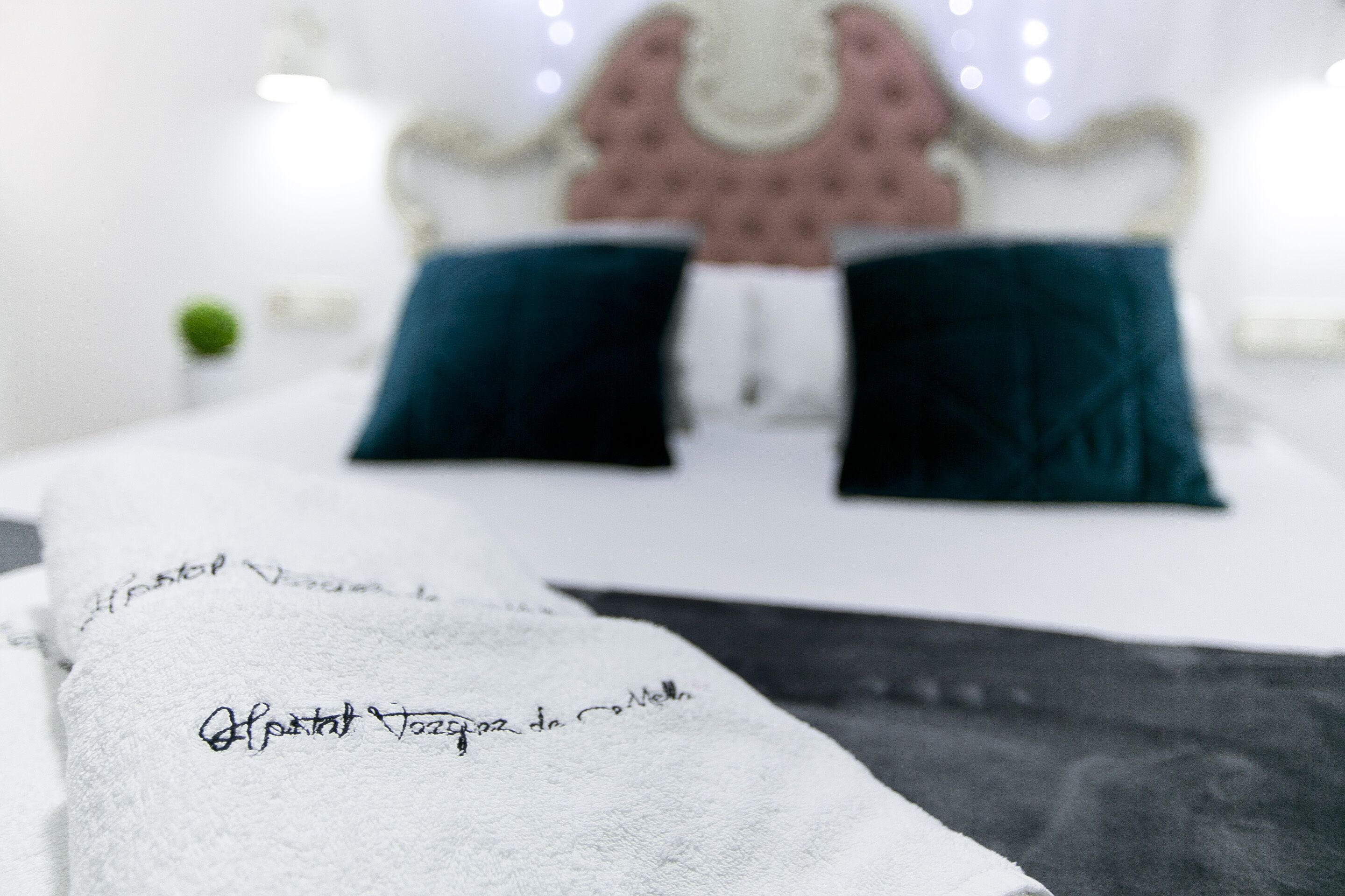A neatly made bed with a white towel and a handwritten note.