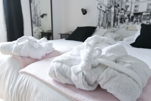Una cama bien hecha con toallas blancas y un edredón rosa.