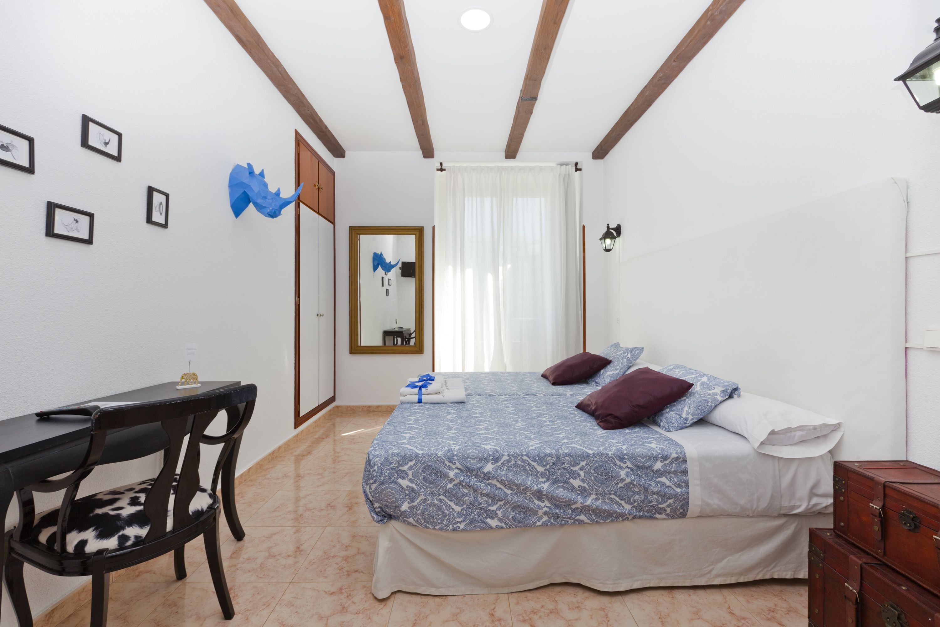 Ein Schlafzimmer mit Bett, Schreibtisch, Stuhl und Kommode.
