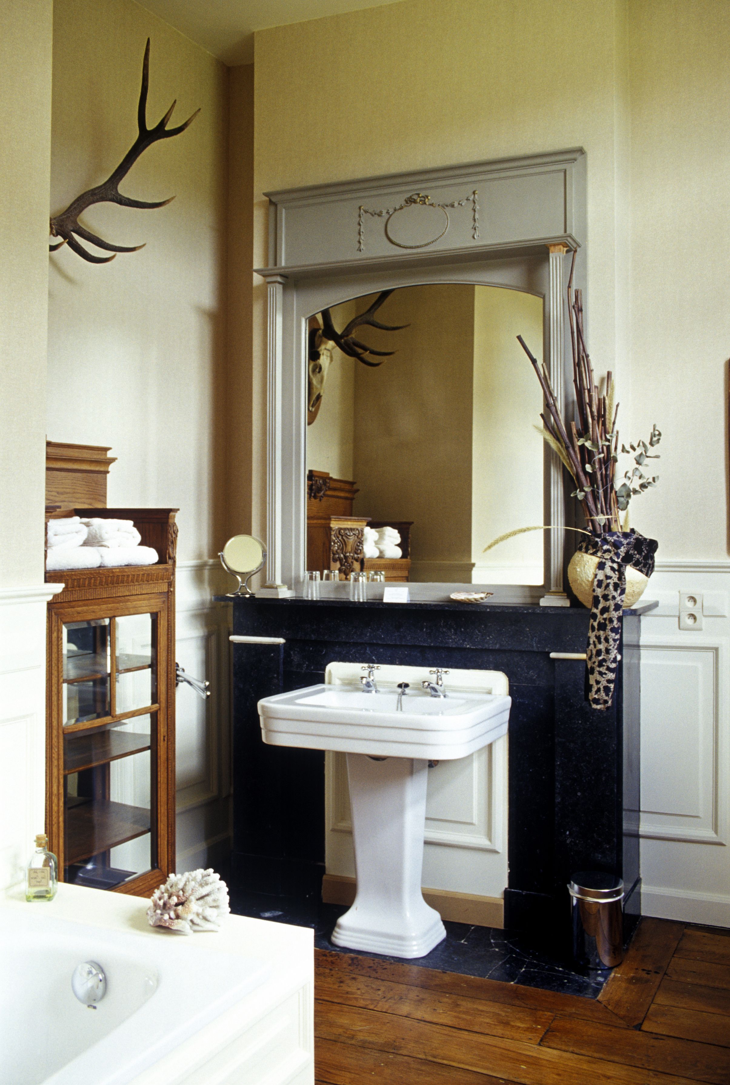 A bathroom with a white sink, a mirror, and a wooden cabinet.