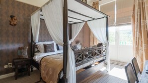 A four-poster bed with white drapes, a wooden headboard, and a patterned bedspread. - Hotel Dufays (Stavelot)