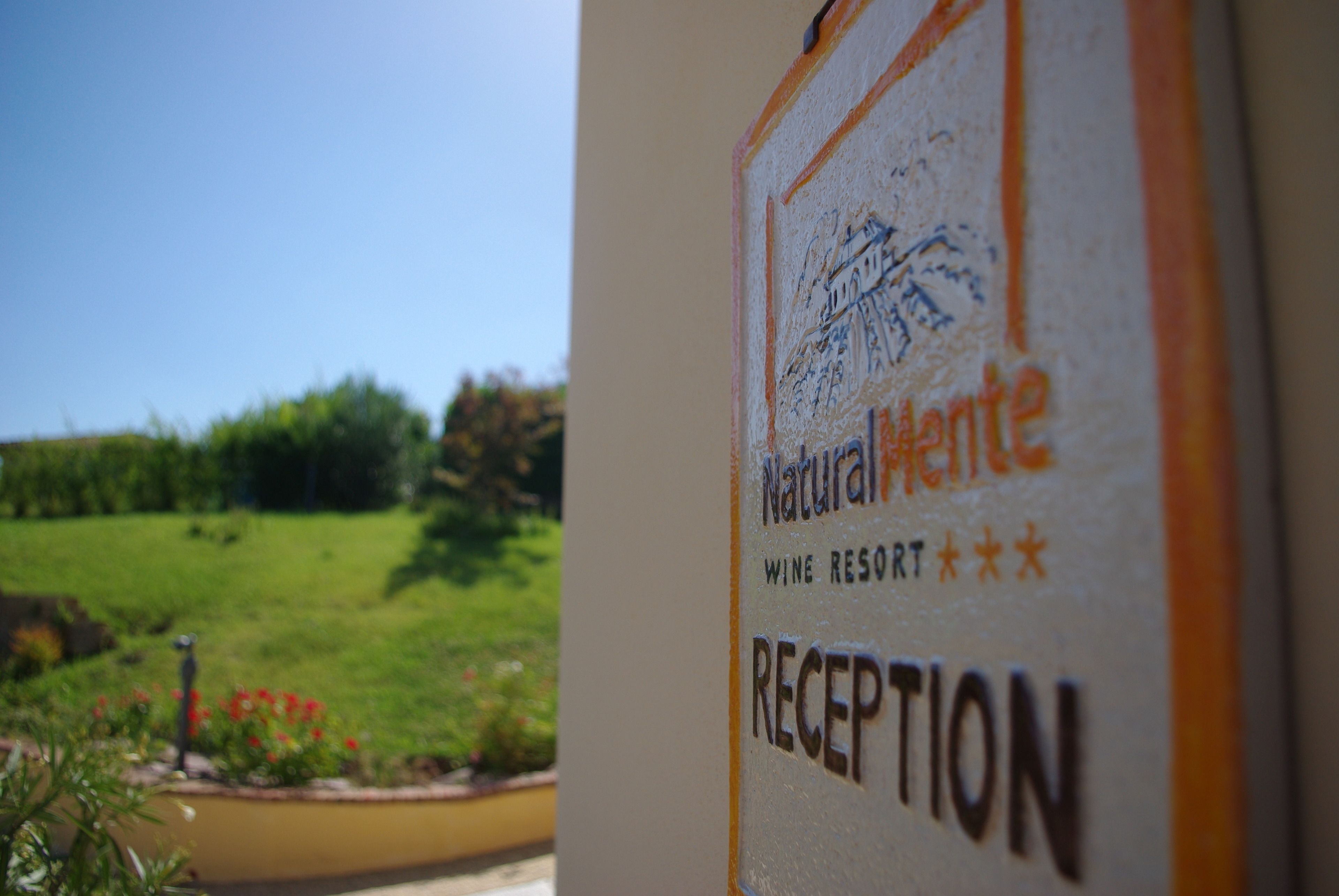 Schild für die Rezeption des Naturalmente Wine Resorts.