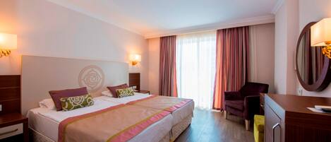 Habitación de hotel con una cama doble, un escritorio, una silla y un espejo.