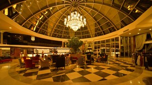 A spacious lobby with a checkered floor, a central chandelier, and a large indoor plant. - Side Alegria Hotel & Spa - Adults Only - All inclusive (Manavgat)