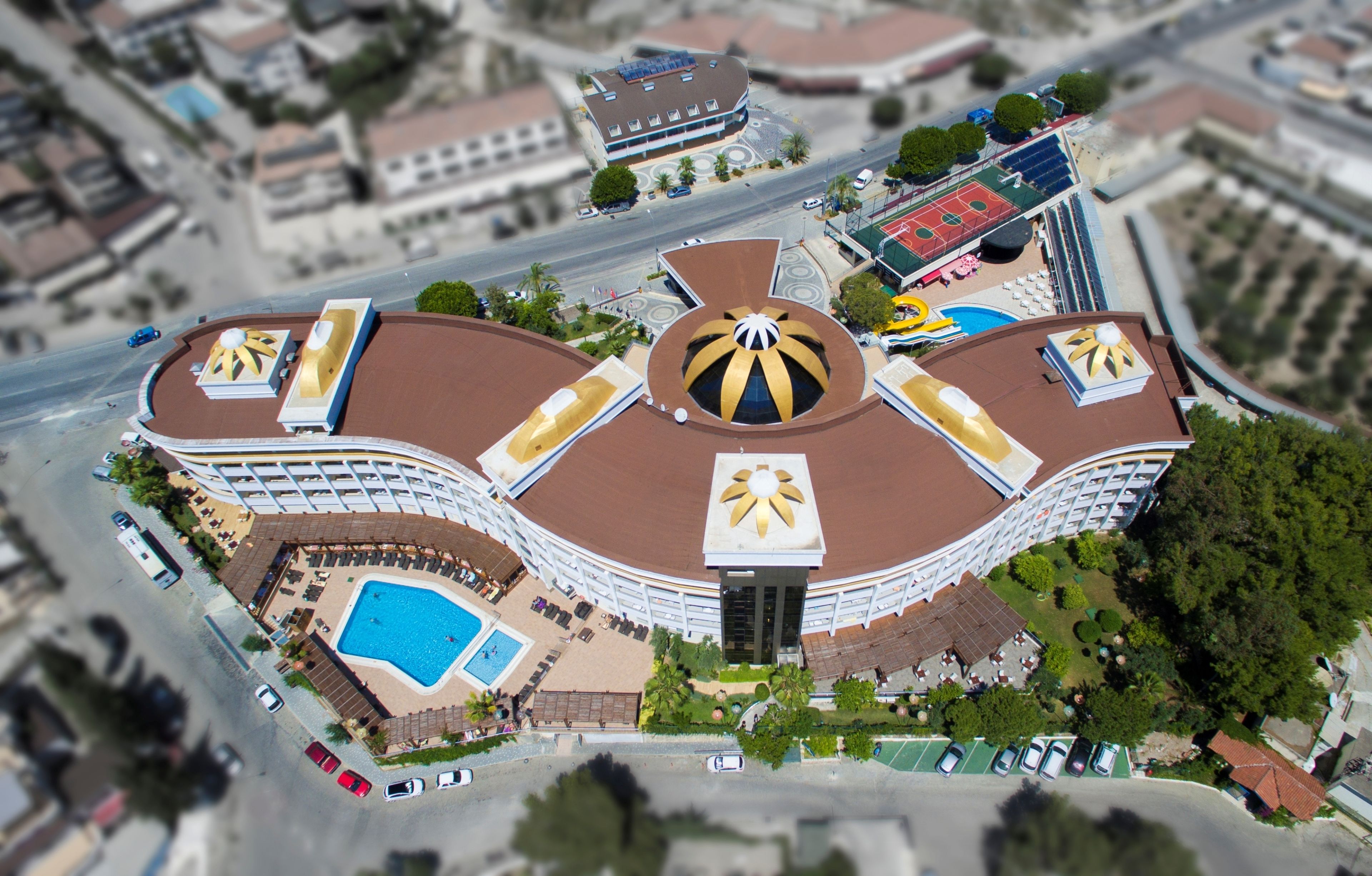Un grand hôtel doté d’un dôme central, d’une piscine et d’un court de tennis.
