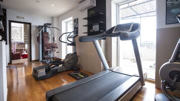 A home gym with a treadmill, elliptical, and stationary bike.
