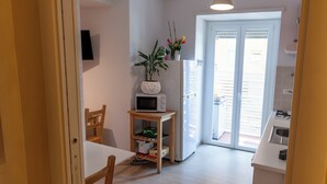 Una cocina moderna con microondas, lavaplatos y zona de comedor con mesa y sillas.