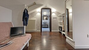 A modern loft bedroom with a sloped ceiling, a built-in wardrobe, and a wooden floor. - B&B Macerata (Macerata)