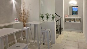 A modern, minimalist bathroom with white fixtures, a no-smoking sign, and a view of the outside through a window. - B&B Macerata (Macerata)