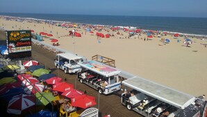 Una playa con un carrito de comida y sombrillas.