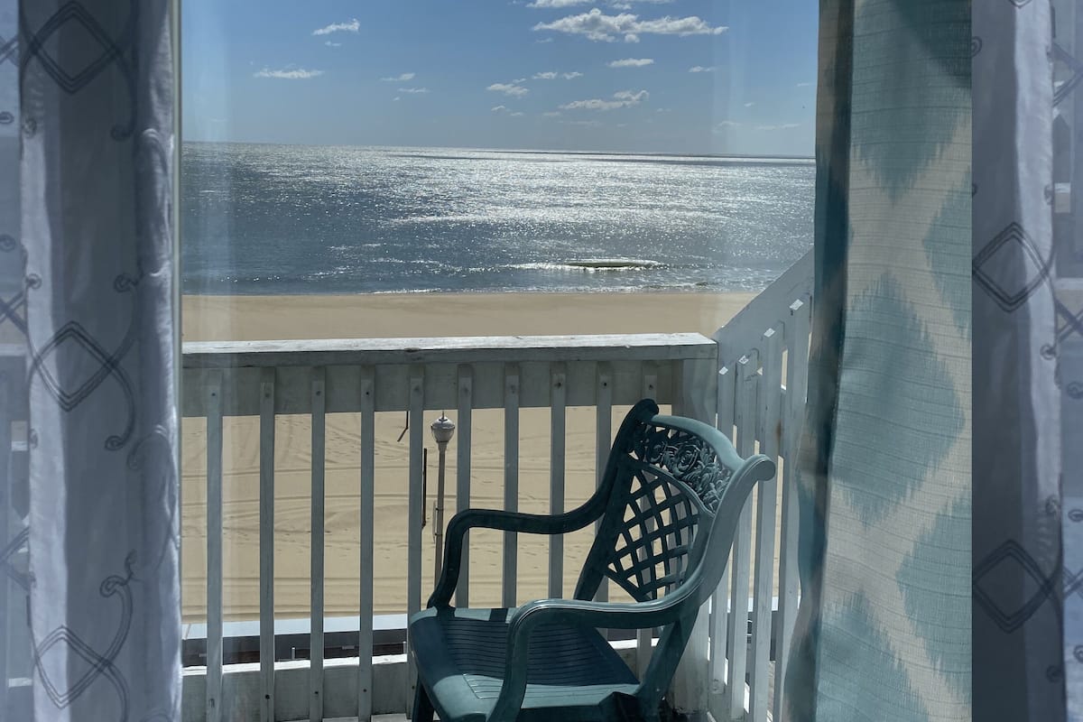 Ein Balkon mit Blick auf Strand und Meer.