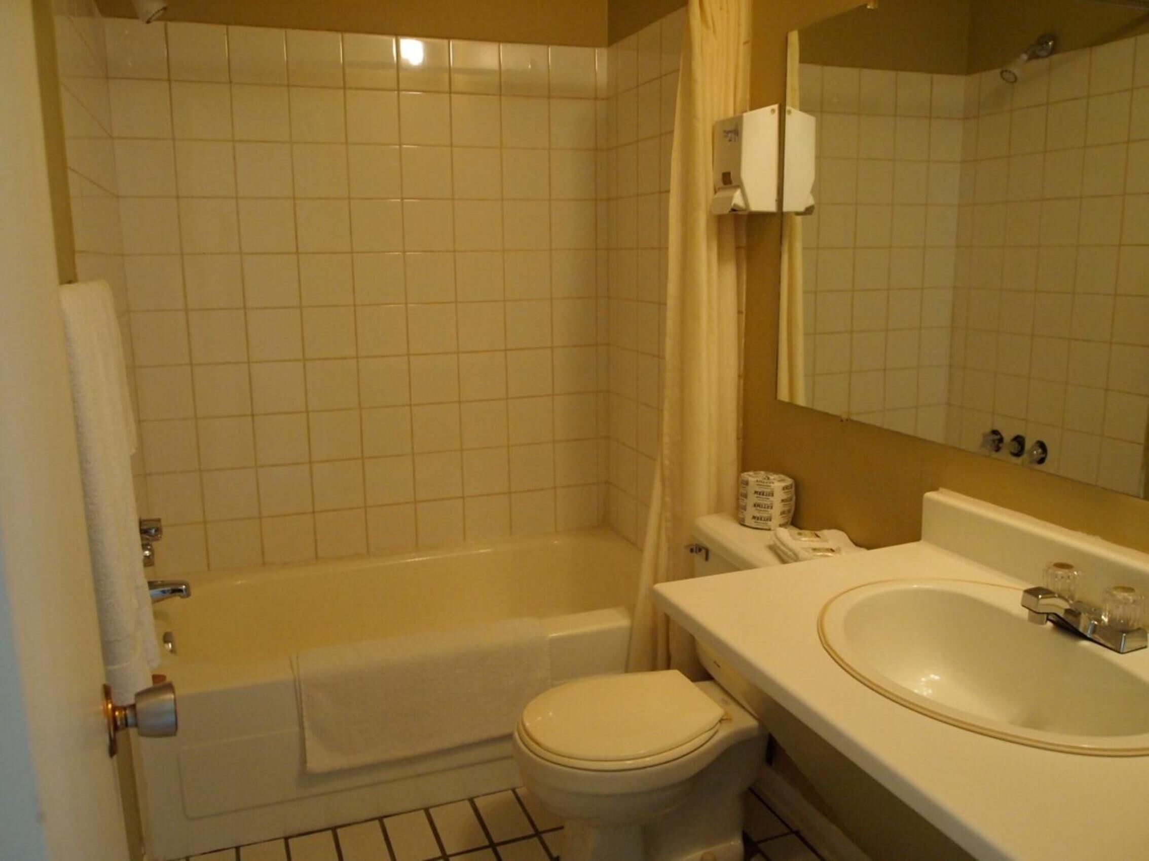 A bathroom with a bathtub, toilet, and sink.