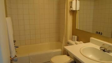 A bathroom with a bathtub, toilet, and sink.