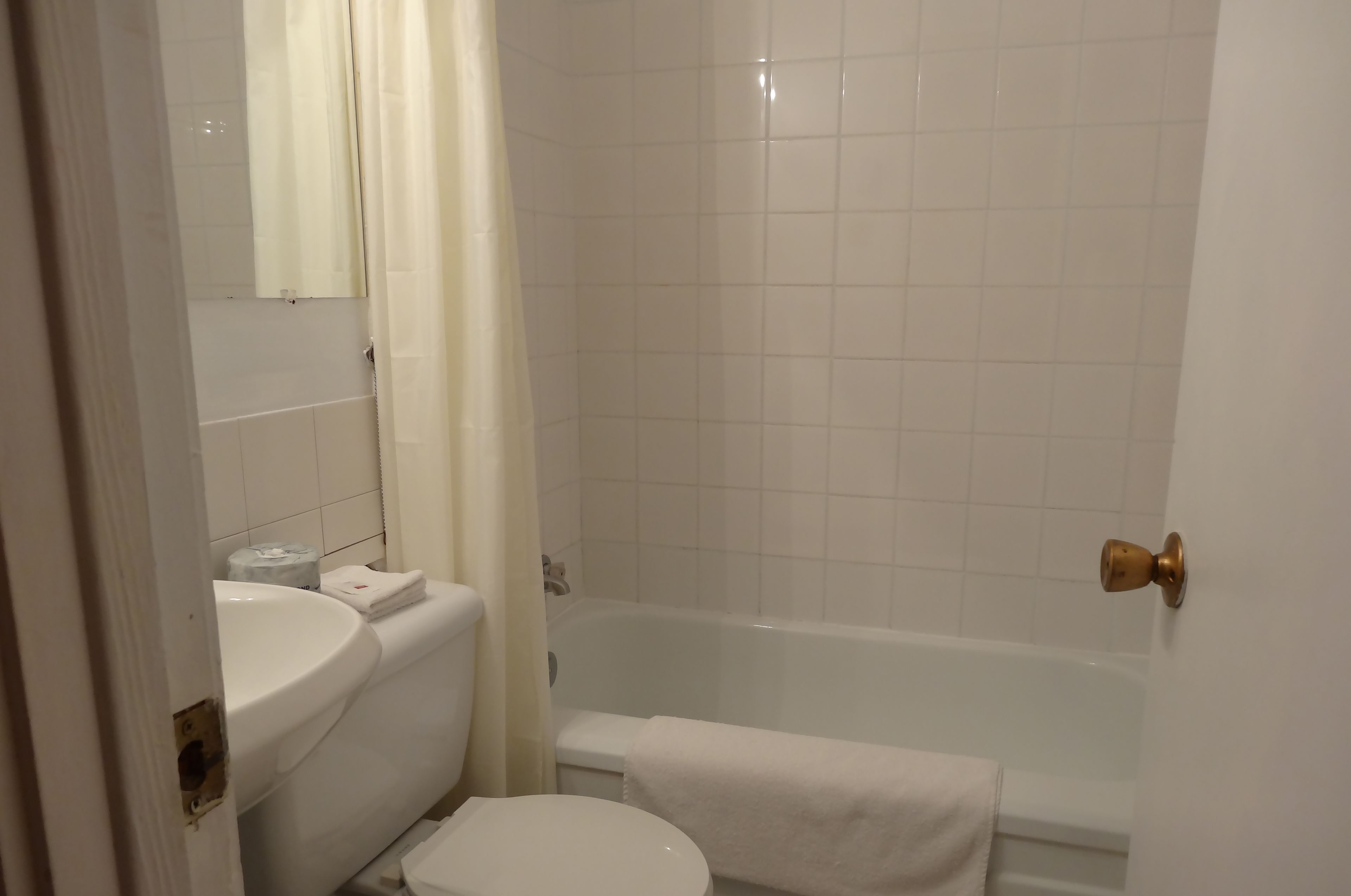 Une salle de bain avec des toilettes, un lavabo et une baignoire.