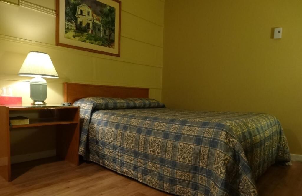 Une chambre à coucher avec un lit, un bureau et une lampe.