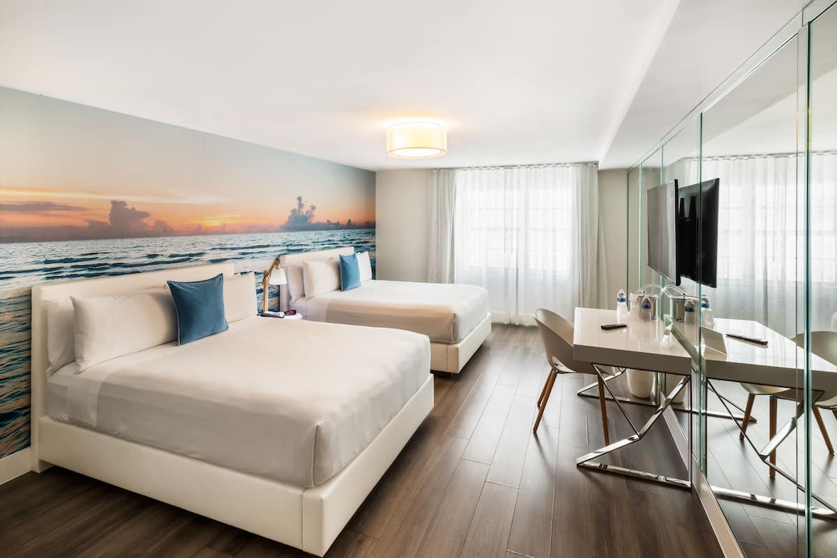 A hotel room with a bed, a desk, and a TV.