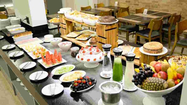 A buffet with various food items and a cake on a counter. - Carlton Plaza Hotel Uberlândia (Uberlandia)