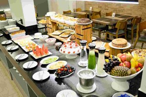 A buffet with various food items and a cake on a counter. - Carlton Plaza Hotel Uberlândia (Uberlandia)