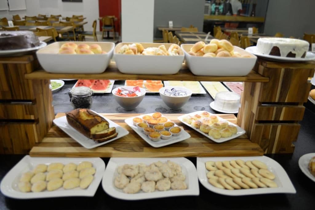 A buffet with various food items including pastries, muffins, and a cake.