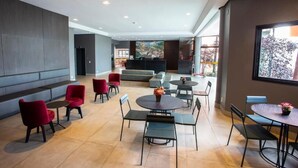 A modern lobby with seating areas, a reception desk, and a large window offering a view of the outdoors. - Carlton Plaza Hotel Uberlândia (Uberlandia)