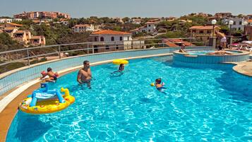 Una piscina al aire libre de temporada, sombrillas