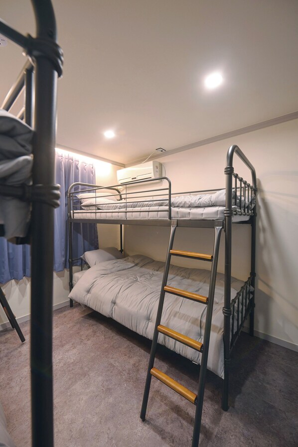 A bunk bed room with a ladder, a window with curtains, and an air conditioning unit. - Hi There design guesthouse (Seoul)