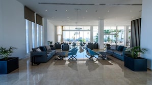 Eine geräumige Lobby mit moderner Sitzgelegenheiten, großen Fenstern und Blick auf die Stadt.