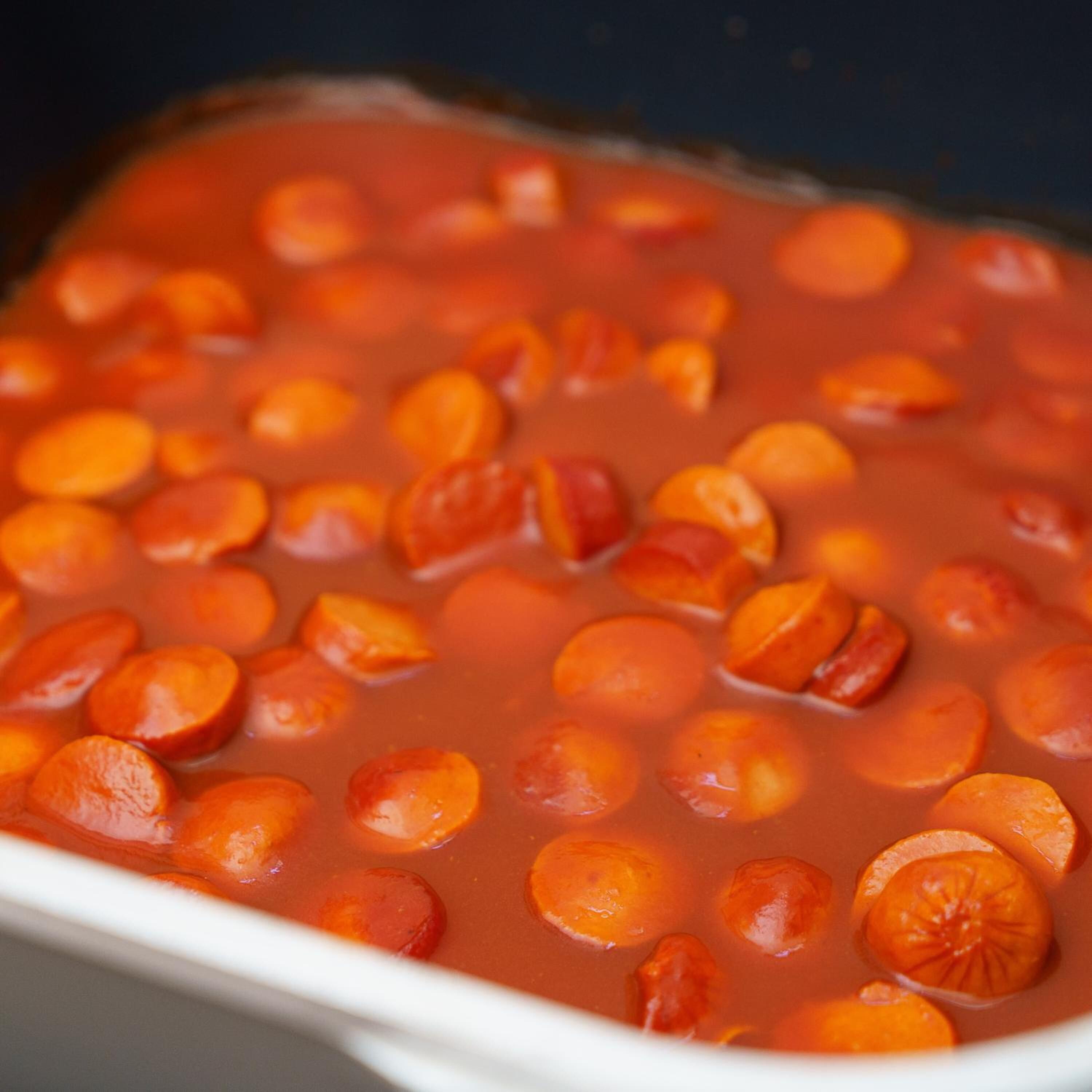 Un plato de cerámica blanca con salsa roja y rodajas de naranja.