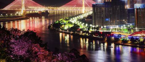 A nighttime view of a cityscape with illuminated bridges and buildings.