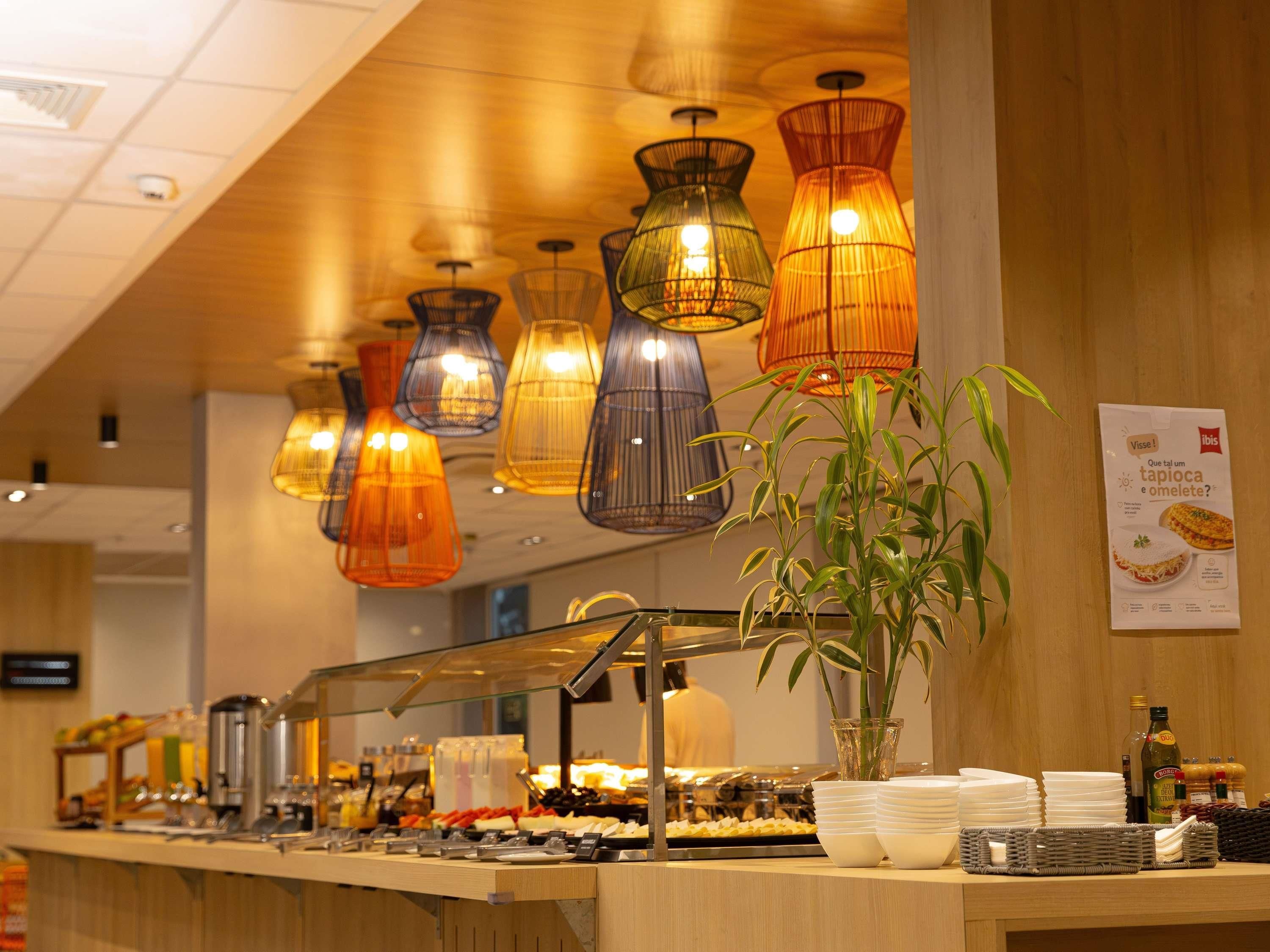Uma área de buffet com diversas opções de comida e um aviso indicando as opções de café da manhã.