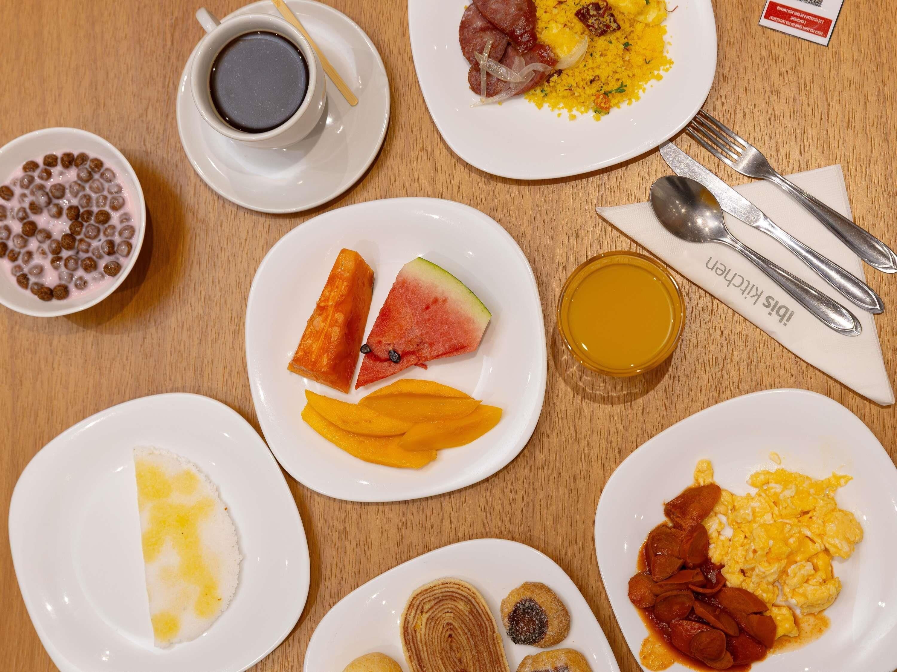Un desayuno con diversos platos, como huevos, tostadas y fruta.