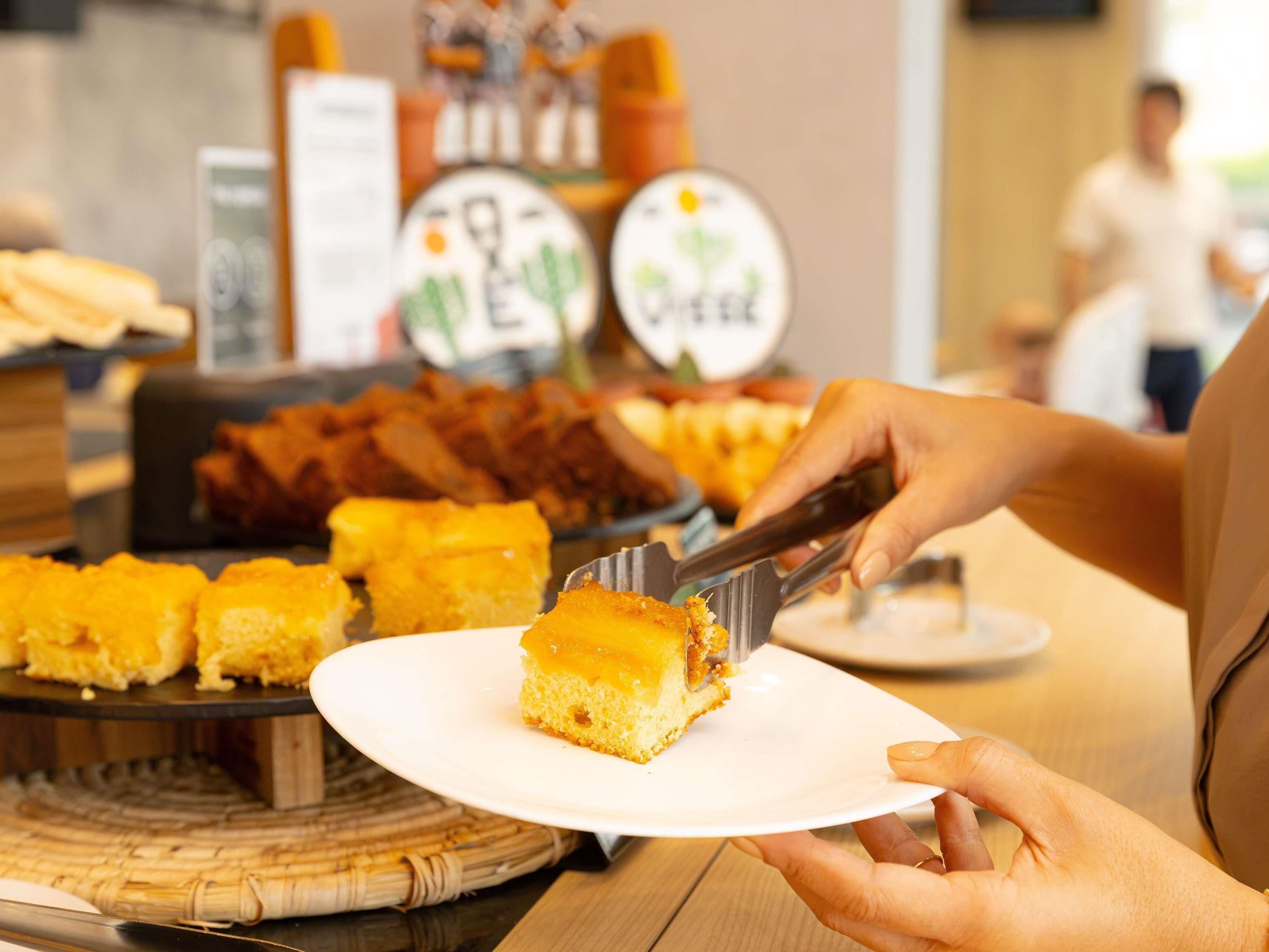 Una persona sirviendo un trozo de pastel desde una bandeja.