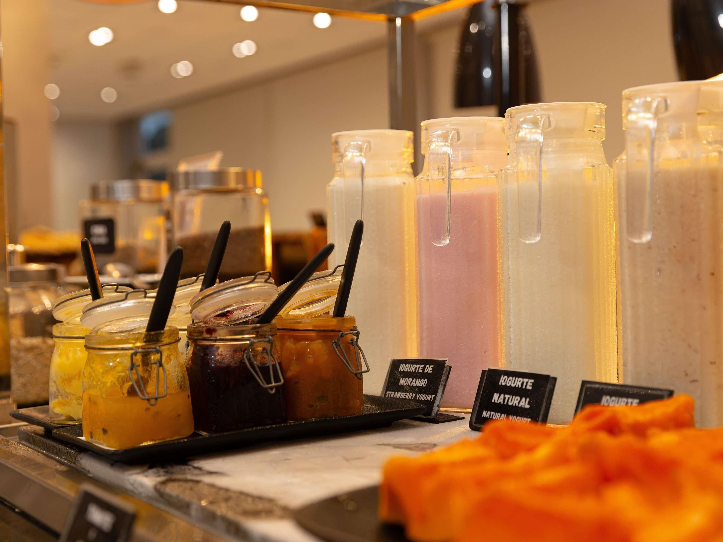 Estação de bebidas de acesso livre com diversos tipos de iogurte e leite.