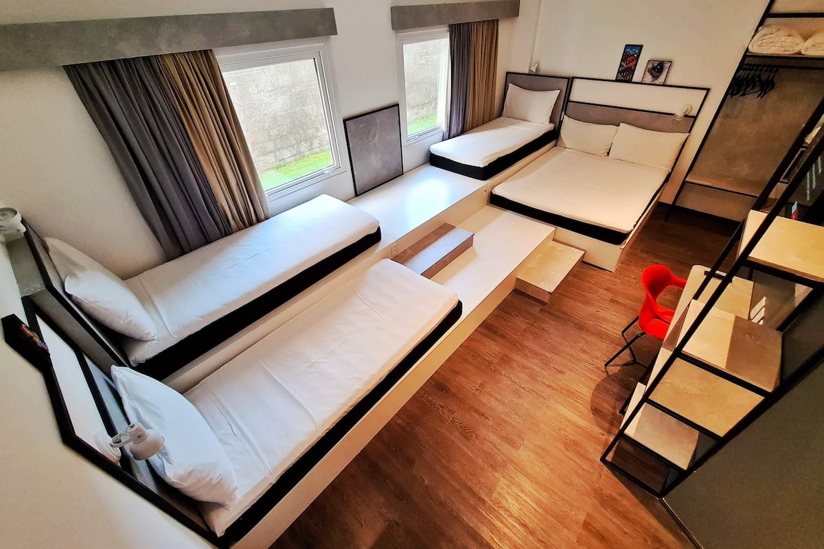 A compact room with bunk beds, a small table, and a chair.