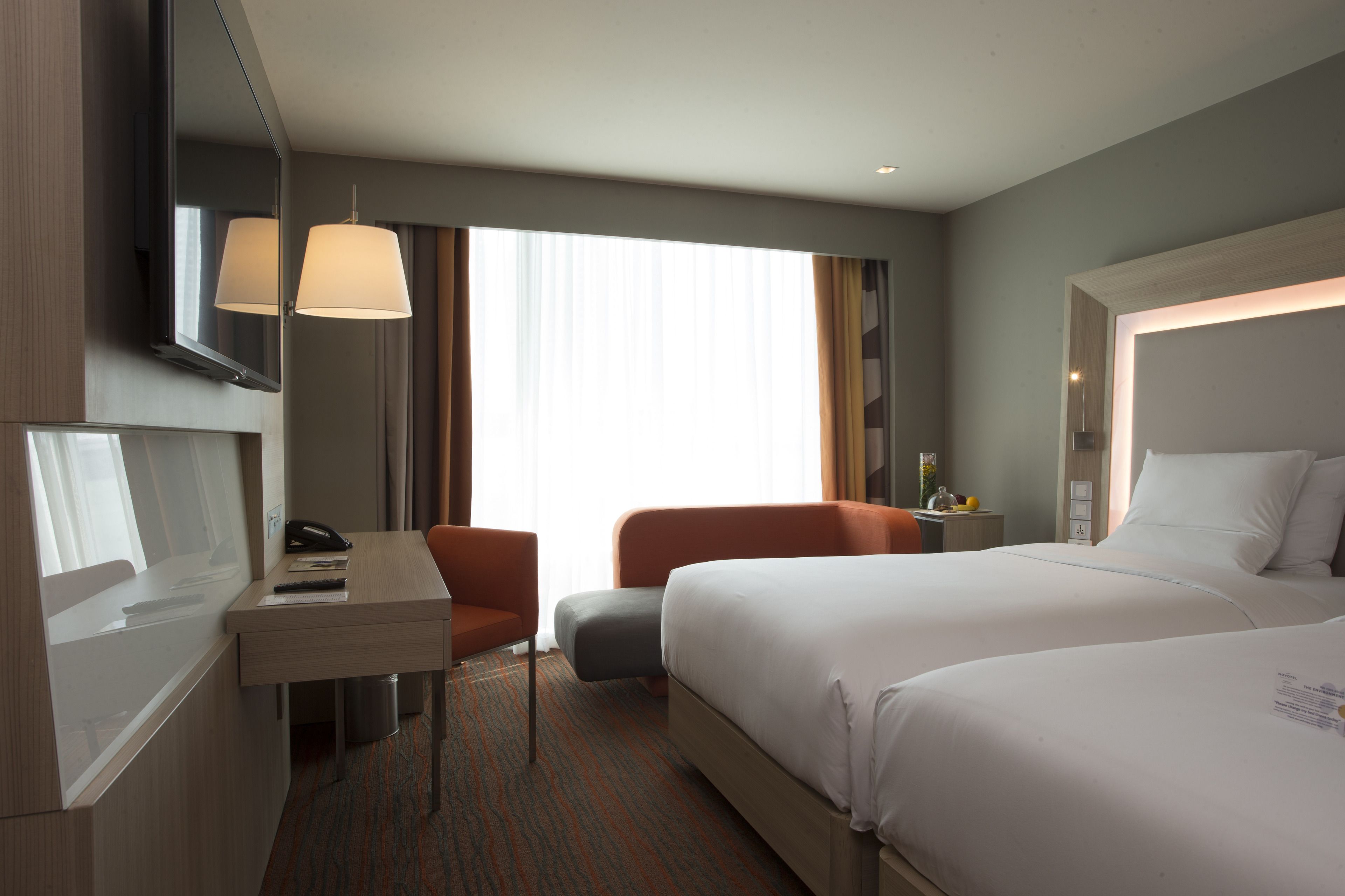 Une chambre d’hôtel avec un lit, un bureau, une chaise et un téléviseur.