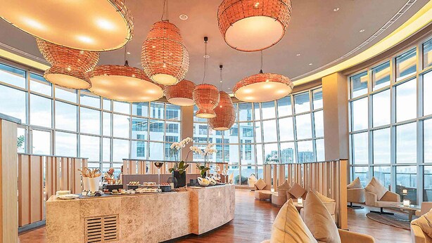 A spacious lobby with a central counter, large windows, and multiple seating areas. - Novotel Manila Araneta City Hotel (Quezon City)