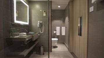 Une salle de bain moderne avec une douche à parois de verre, un meuble-lavabo avec un miroir et des toilettes.