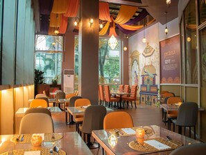 A restaurant interior with tables, chairs, and decorative elements. - Novotel Manila Araneta City Hotel (Quezon City)