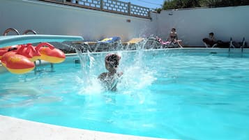 A swimming pool with inflatable toys and a person in the water.