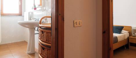 A bathroom with a sink, mirror, and wicker baskets.